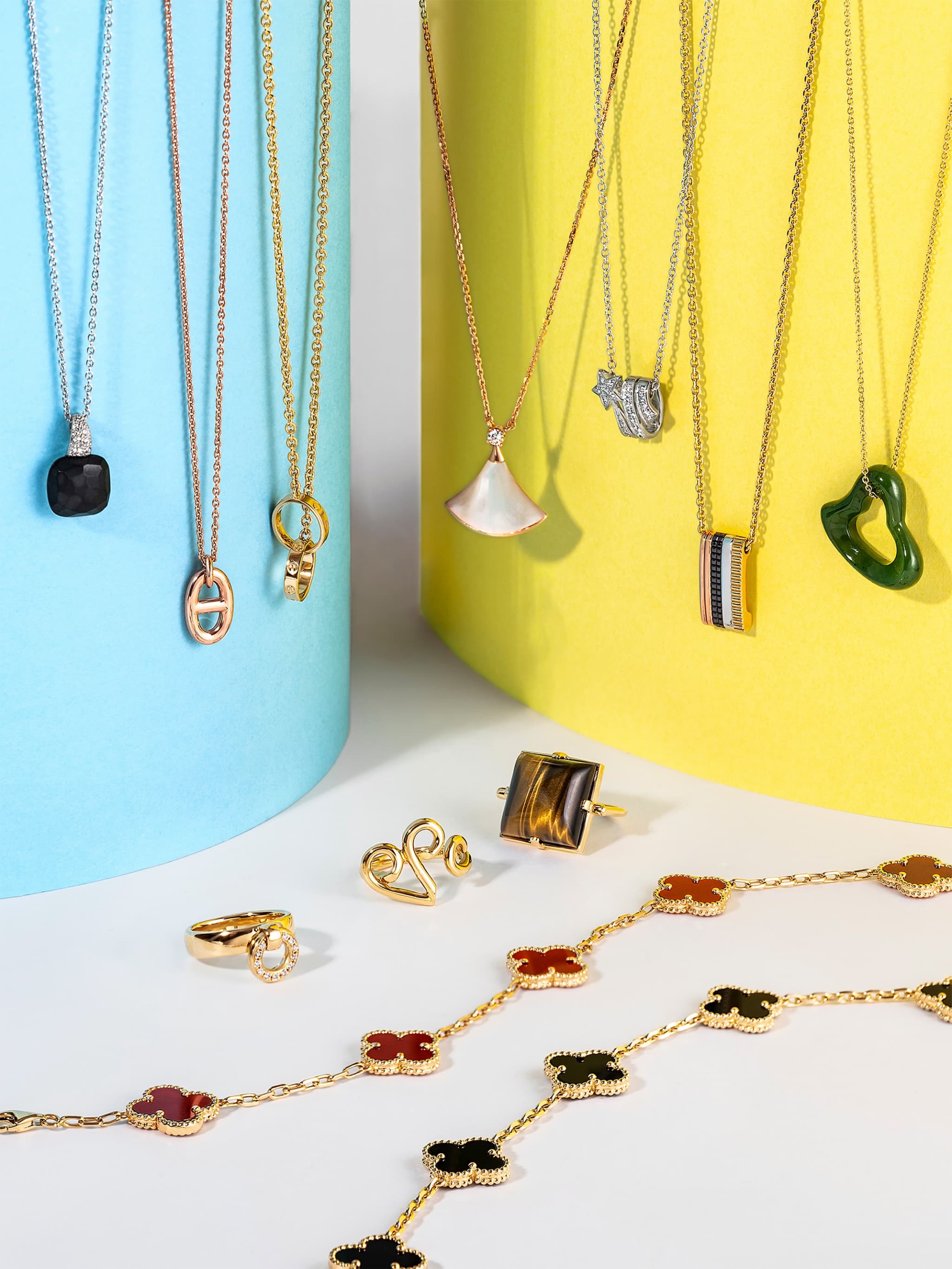 カラフルな円柱に掛けたペンダントと、四つ葉モチーフのロングネックレス